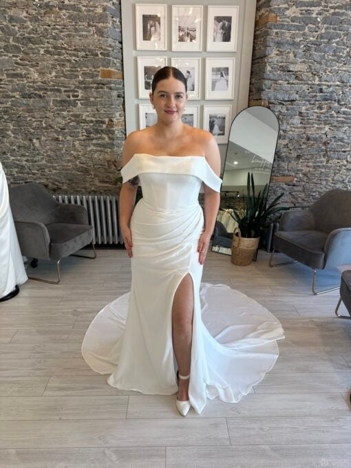 Gentry a fitted crepe wedding dress with a leg slit, rouching from the hip and a soft arm band.