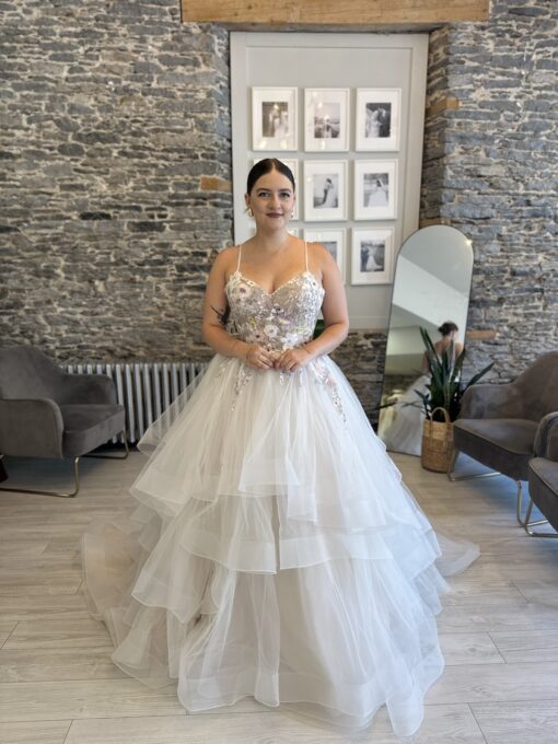 Reem, A flirty floral wedding dress with ruffled layers.