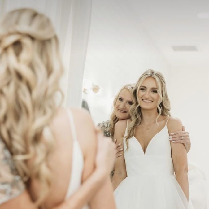 Bride and her mom looking in the mirror