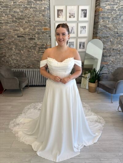 Lyall a modern classic—an off-the-shoulder satin gown with delicate floral beading and lace train
