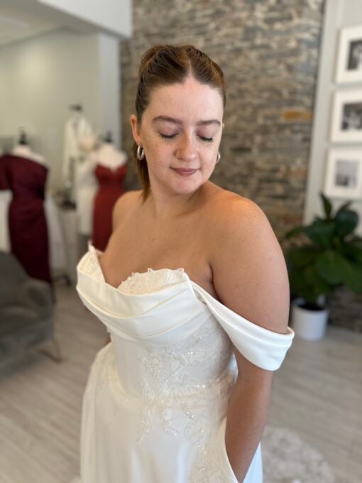 Lyall a modern classic—an off-the-shoulder satin gown with delicate floral beading and lace train