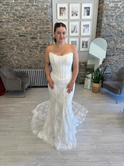 Bride wearing a fitted sheet-lace dream with a touch of vintage corsetry and removable sleeves.