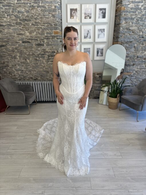 Bride wearing a fitted sheet-lace dream with a touch of vintage corsetry and removable sleeves.